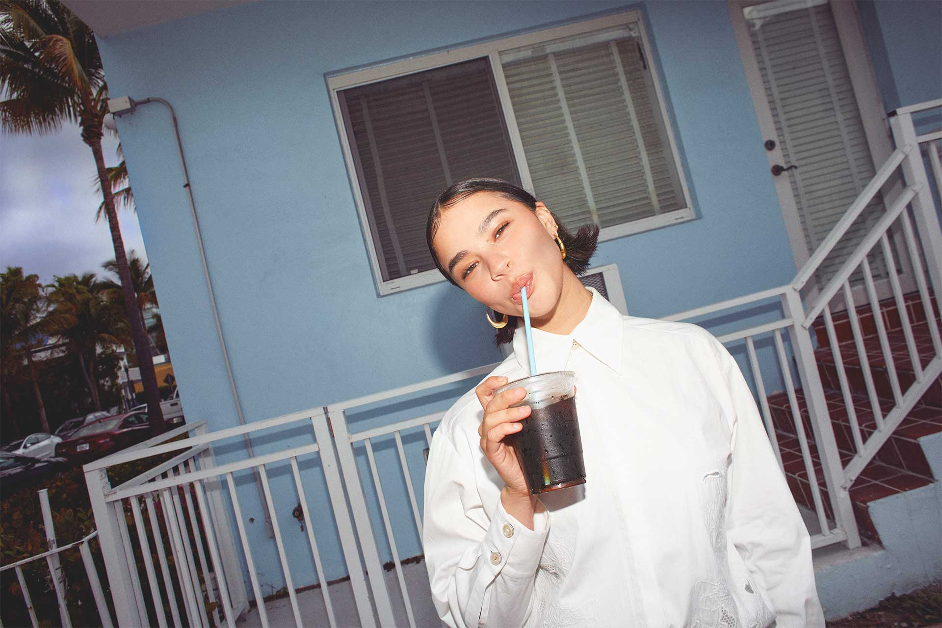 Edie Rose drinking coffee wearing white shirt