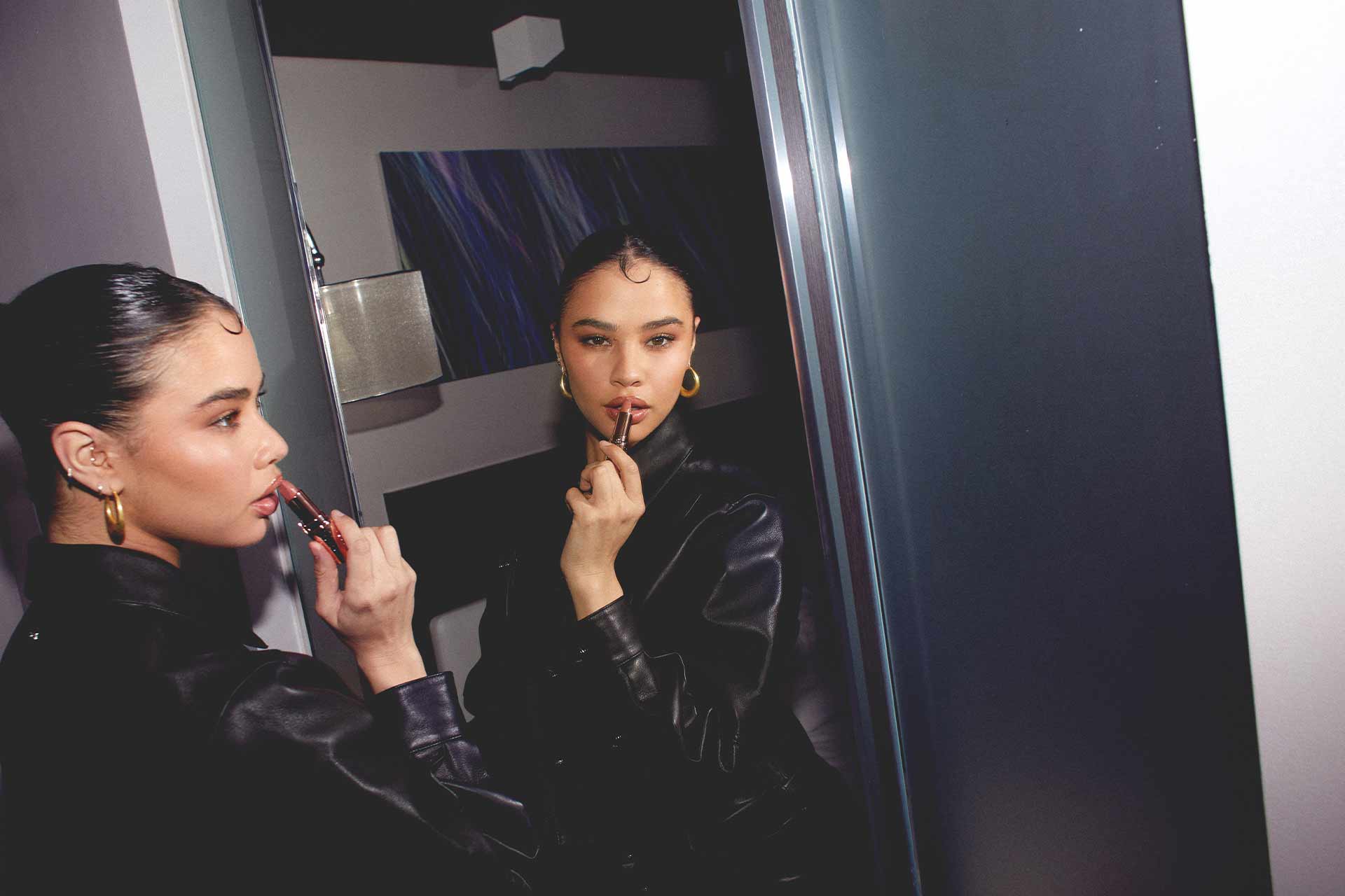 Edie Rose applying lipstick in mirror