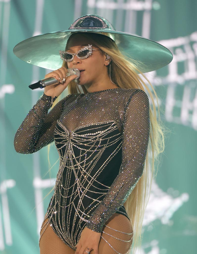 Beyonce singing at Renaissance World Tour in glittery bodysuit, sunglasses and hat
