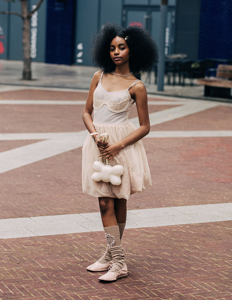 Street style image of a girl wearing a dress and ballet flats