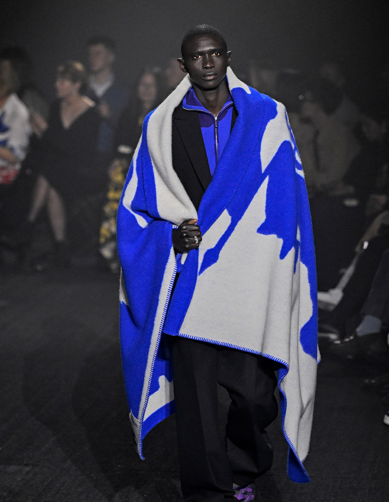 Man in black suit with a poncho sporting the Burberry Knight 