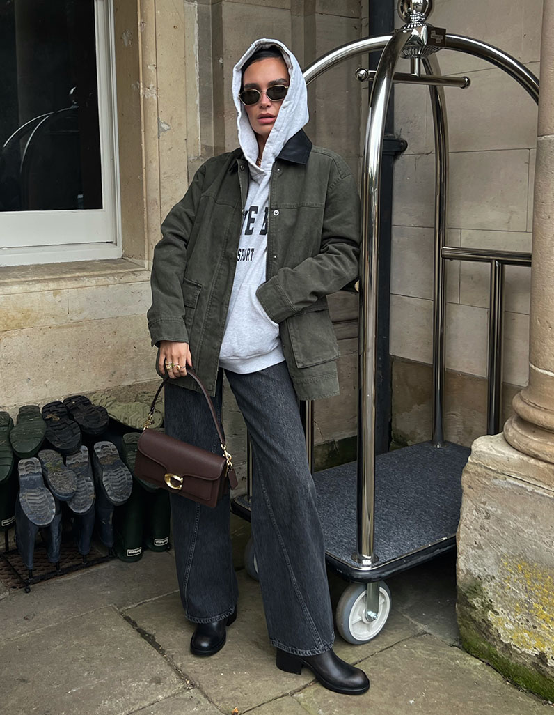 Alicia Roddy in Annie Bing jeans, sports hoodie and barn jacket with a Tabby shoulder bag from Coach.