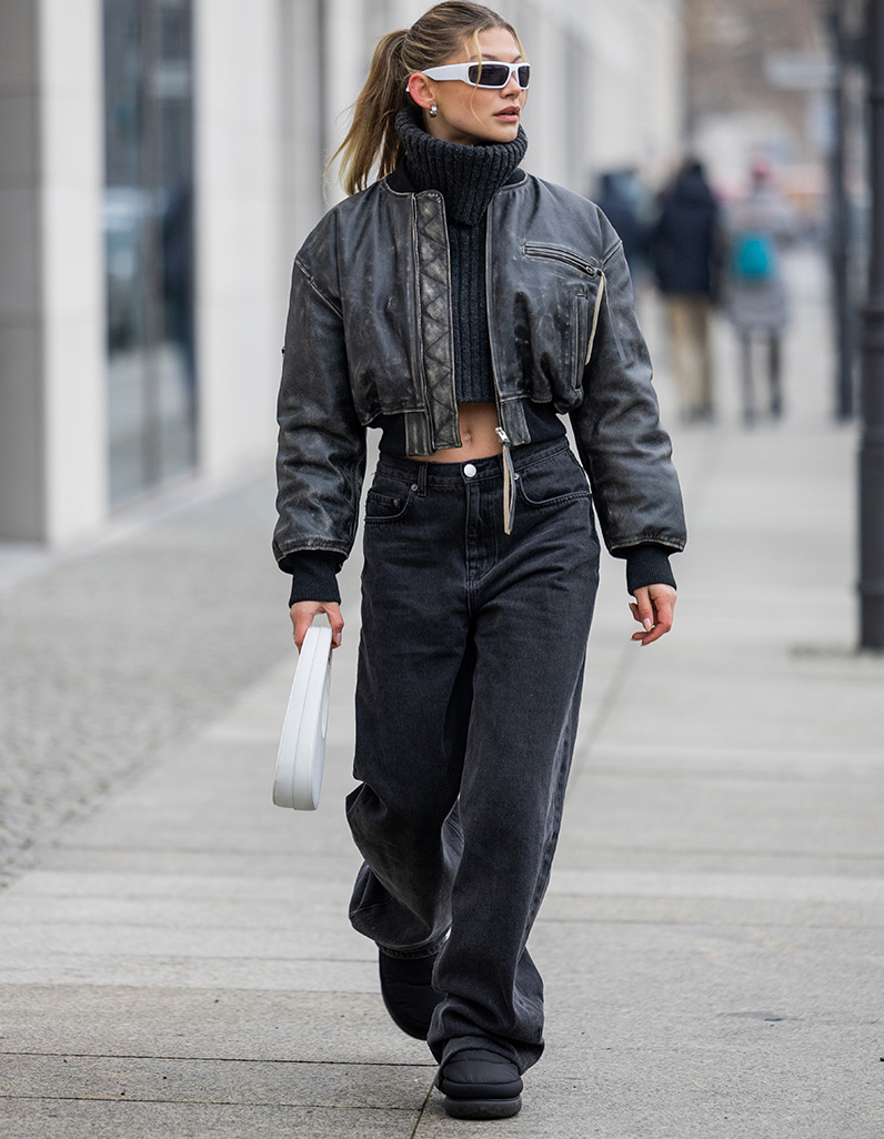 women in black jeans, leather jacket and cropped knit 